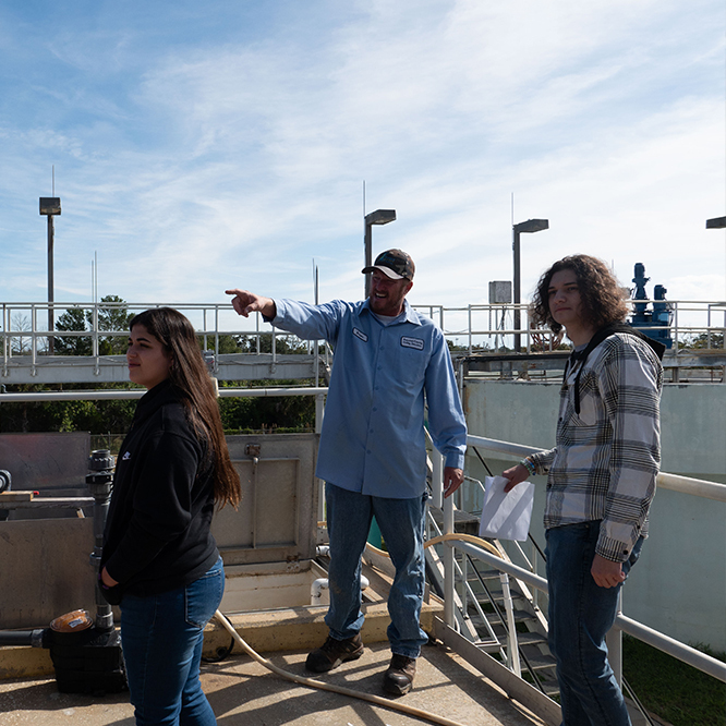 Utilities plant operator showing kids the water treatment system