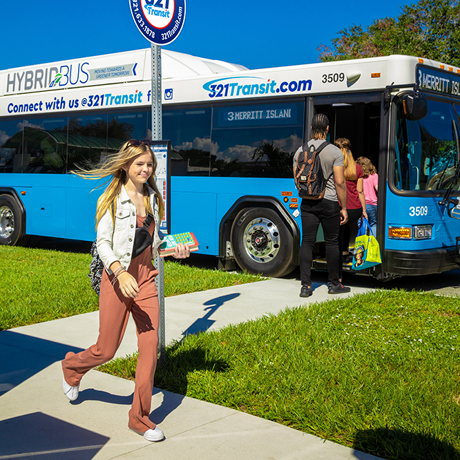 Teen walking off 321Transit bus and group of people boarding bus